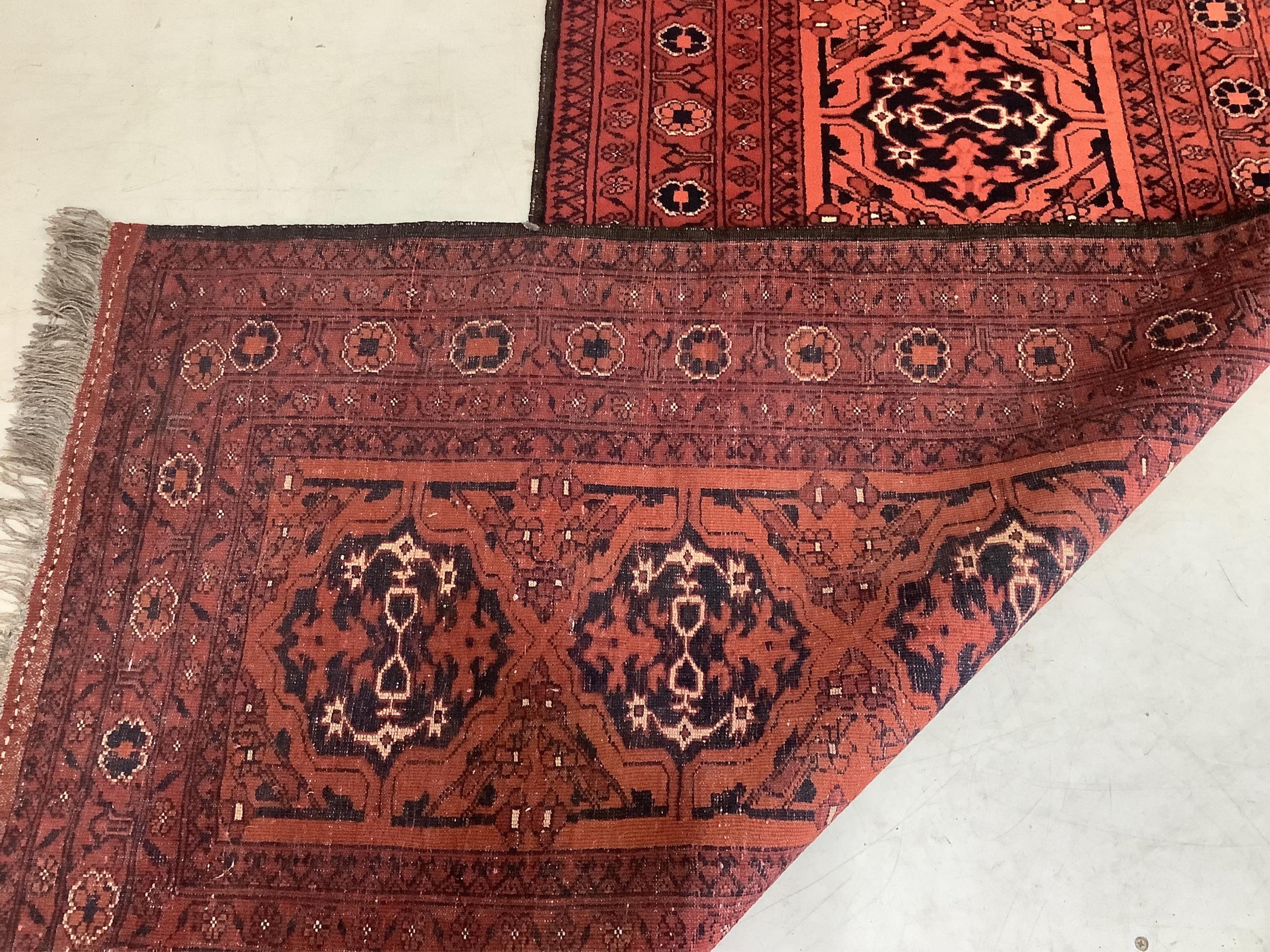 An Afghan red ground runner, approximately 400 x 86cm. Condition - fair